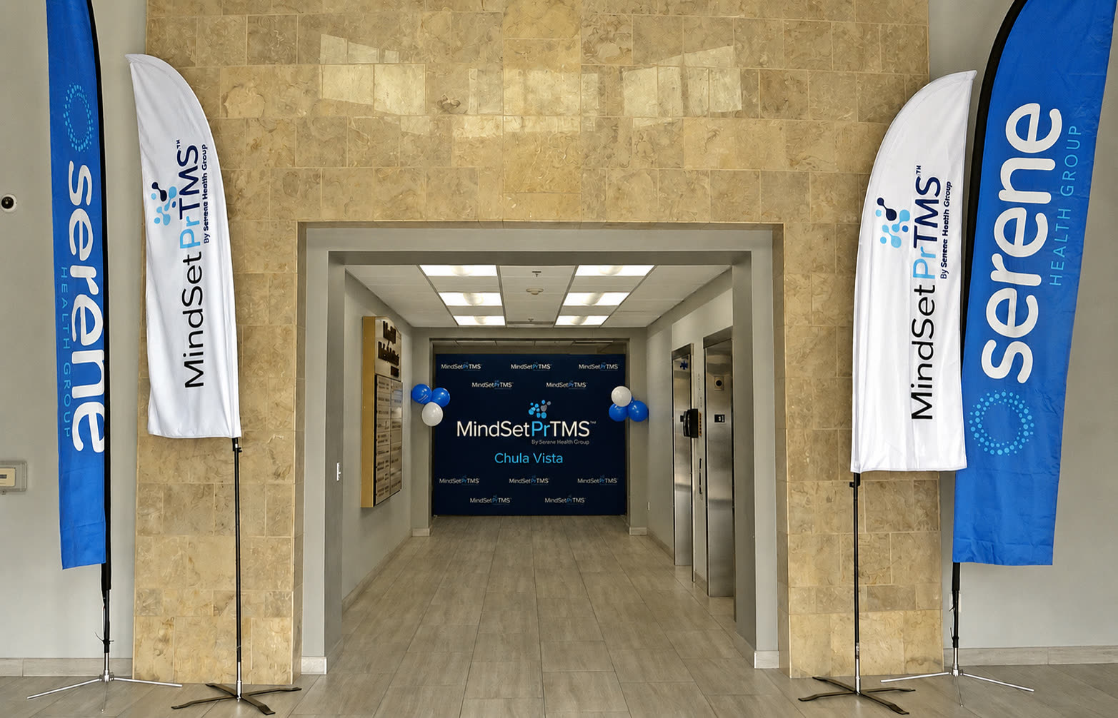 Entrance to the MindSet PrTMS Chula Vista clinic at Eastlake Square, flanked by MindSet PrTMS and Serene Health Group flags