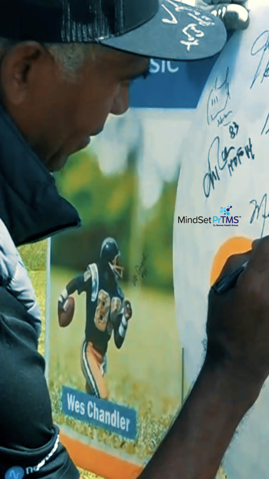 A former NFL player signing a MindSet PrTMS banner at a charity golf event