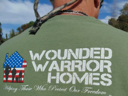 A U.S. veteran at the San Diego Veterans Memorial, with the city skyline and an American flag behind him