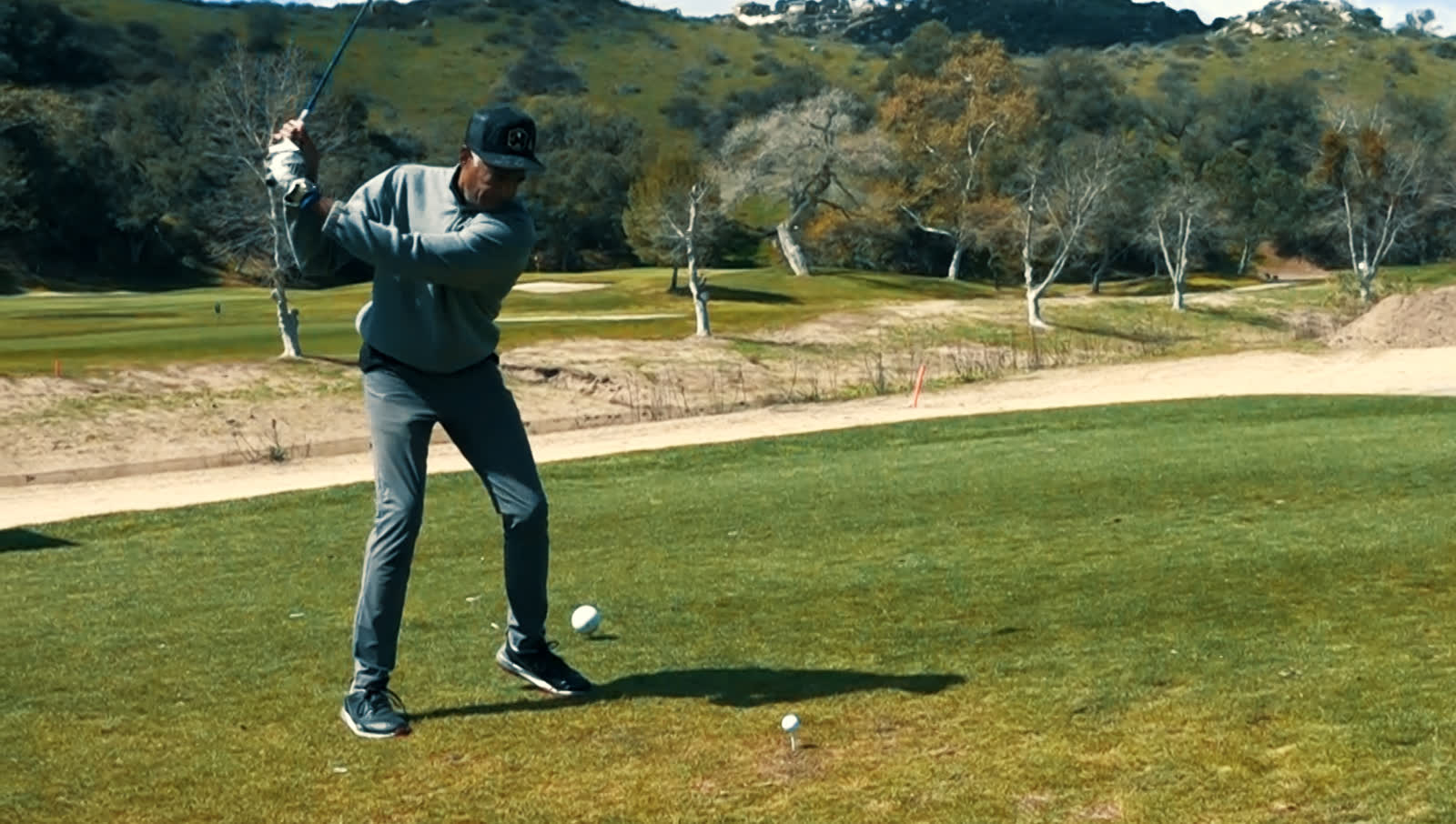 A golfer teeing off at We Support U's Celebrity Golf Tournament on a San Diego course